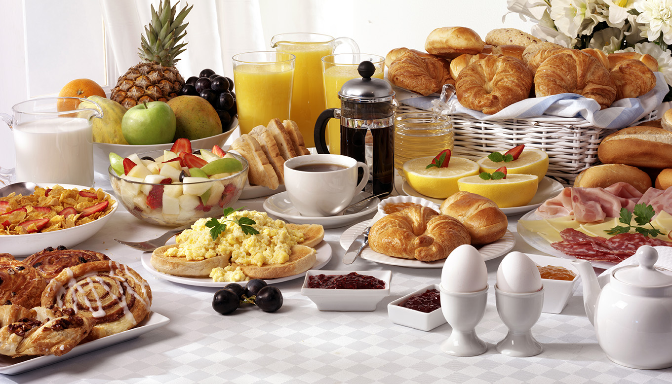 Breakfast,buffet,table,filled,with,assorted,foods,savoury,sweet,pastries,hot,and,cold,drinks