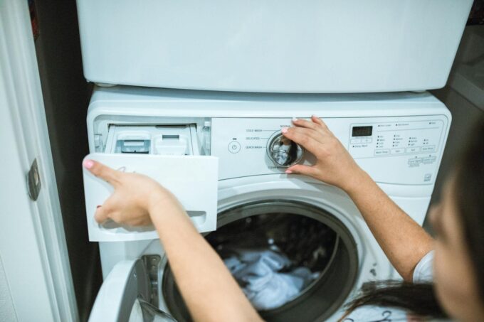 A Person Holding White Front Load Washing Machine