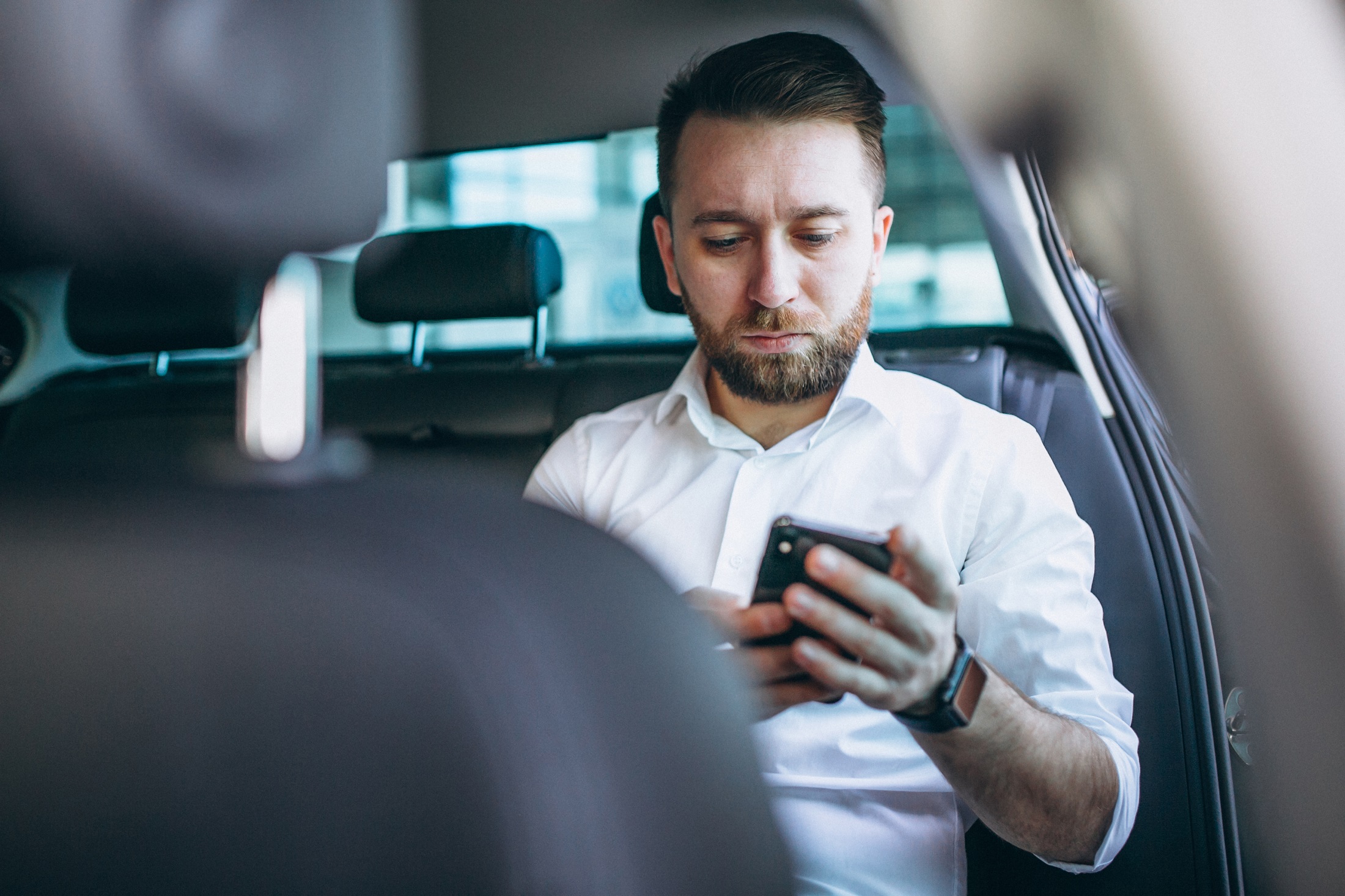 Business Man Sitting In A Car Using Phone